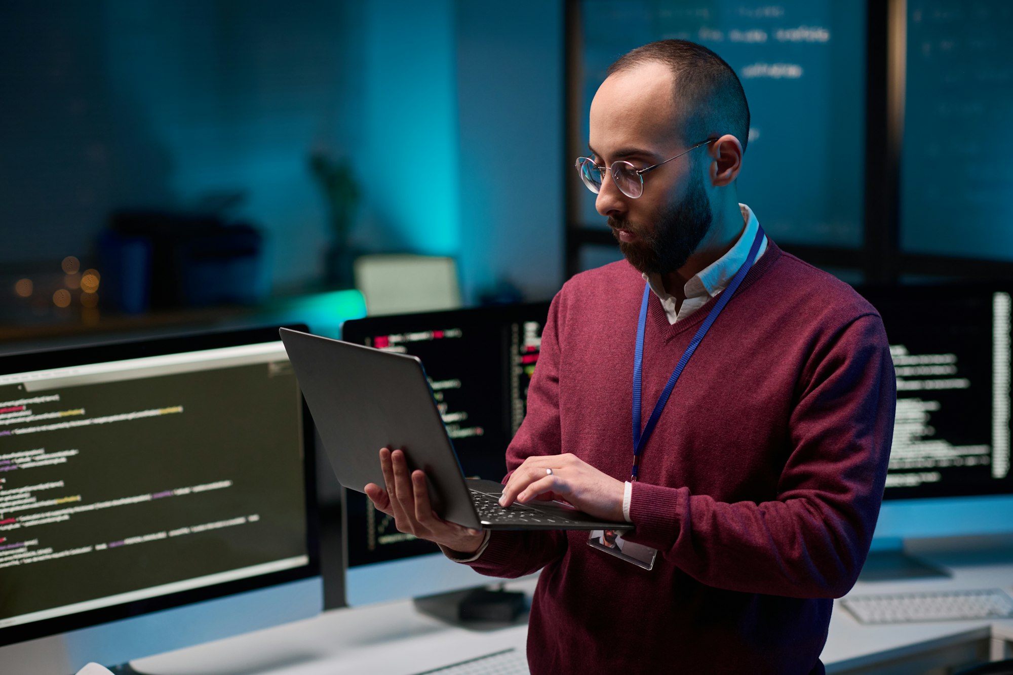 Bearded Man Holding Laptop in Cybersecurity Office