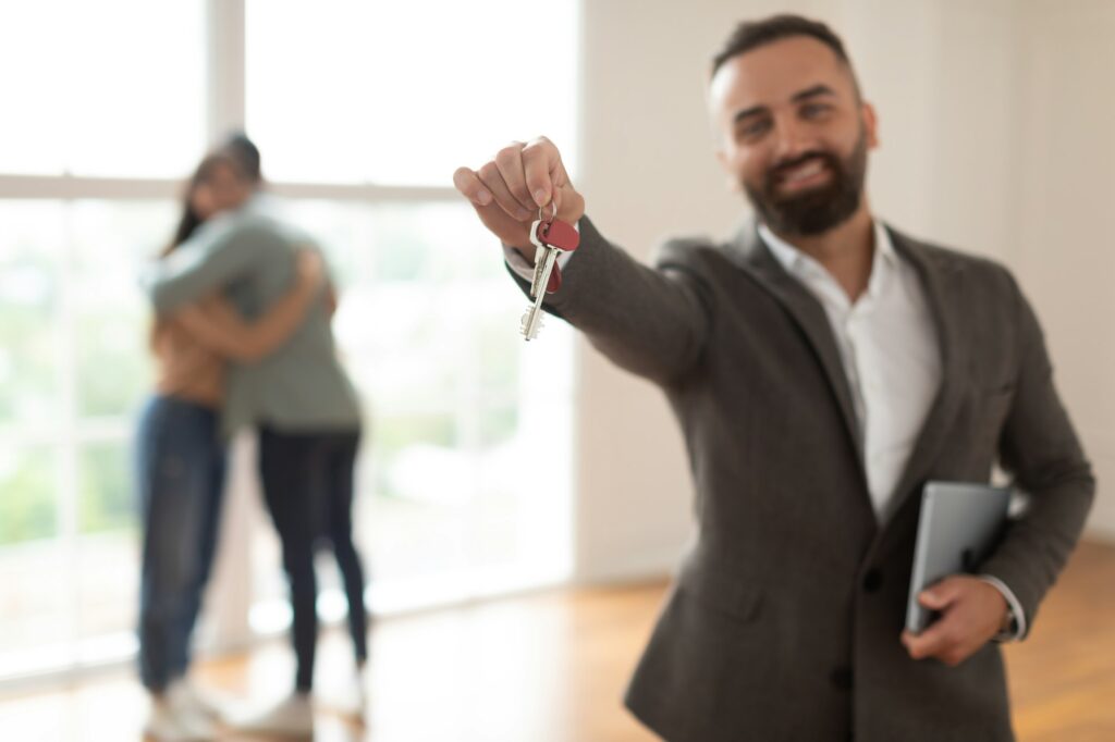 Smiling Real Estate Agent Holding And Showing Key