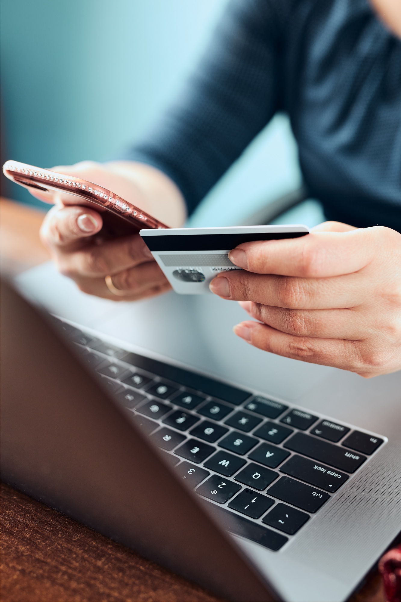 Woman doing online shopping using debit card and laptop. Female hands holding credit card